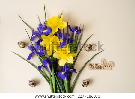 Beautiful floral arrangement of yellow and blue flowers with Easter eggs and the inscription of Happy Easter on a beige background