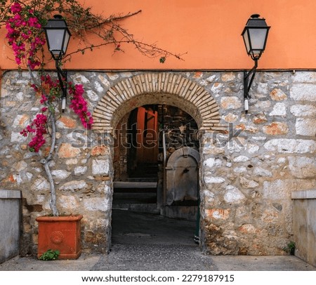 Stone arch in a traditional old terracotta wall between houses in the Old Town of Villefranche sur Mer on the French Riviera, South of France Royalty-Free Stock Photo #2279187915