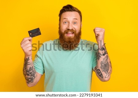 Photo of overjoyed cheerful man wear stylish clothes raise fist hooray celebrate sale shopping isolated on yellow color background