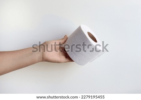 A hand holding a toillet paper 