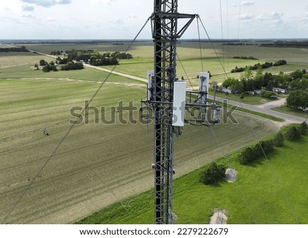 Drone shot of the top of a telecom tower - scenic rural view of fields in the background