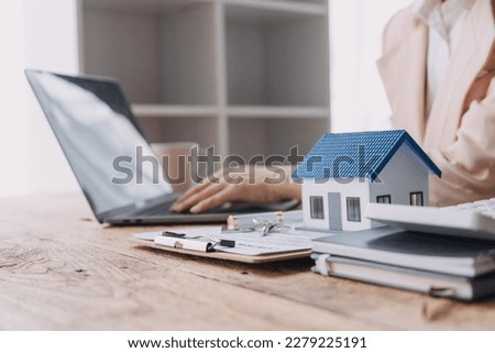 Real estate broker agent presenting and consult to customer to decision making sign insurance form agreement, buy and sell home model, concerning mortgage loan offer for and house insurance Royalty-Free Stock Photo #2279225191