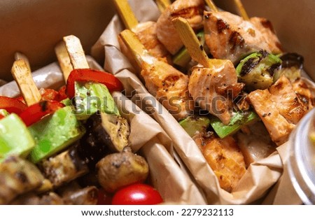 Grilled salmon fish fillet and vegetables cooked on skewers and delivered for lunch in a box. Delicious natural meal for pescatarian or flexitarian diet.  Royalty-Free Stock Photo #2279232113