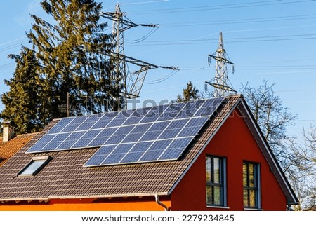 Solar battery on the roof of house near Electrical towers. PV plants generate your own electricity plug play. Power photovoltaic plant. Solar Panel energy system. Royalty-Free Stock Photo #2279234845