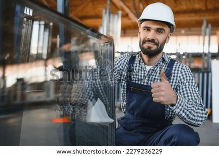 the glazier takes a piece of mirror off the table. Glass factory, manufacture. Royalty-Free Stock Photo #2279236229