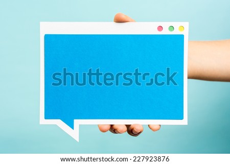 Hand holding blue speech bubble with flat design, mock-up. Internet concept.