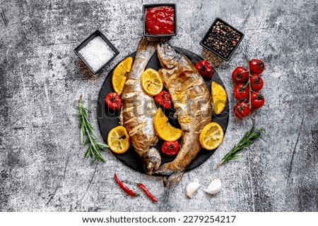 baked trout with lemon, orange, spices on a stone background Royalty-Free Stock Photo #2279254217