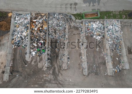 Landfill site, a pile of stinky different junk disposal in the concrete section for unsorted waste materials Royalty-Free Stock Photo #2279283491