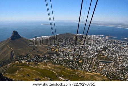 Breathtaking aerial shot of Cape Town, Robben Island and Lion's Head from Table Mountain cable car, featuring visible focused  suspension cables and stunning views of the cityscape and coastline