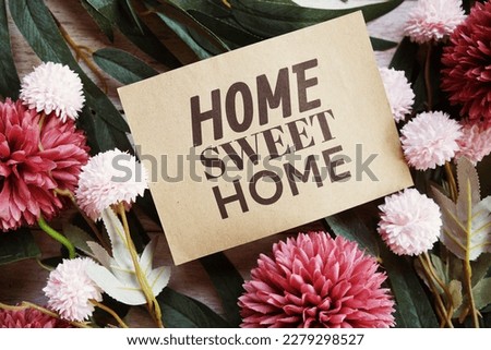 Home Sweet Home text message with flower decoration on wooden background