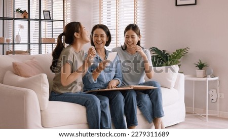 Recall the past life memories Happy time Mother's day grown up kid child joy fun look at old retro photo album with mature mum. Asia adult people middle age mom smile enjoy relax sitting at home sofa. Royalty-Free Stock Photo #2279311689