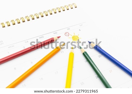 There is a calendar on a white background. A colored pencil pointing to the May 5th of the calendar when is Children's Day in Korea, Asia. The date is marked with a red circle and sun illustration