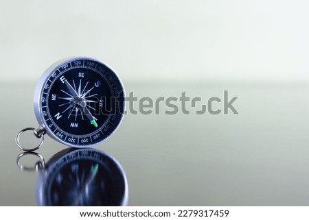 isolated compass lies on a wooden table