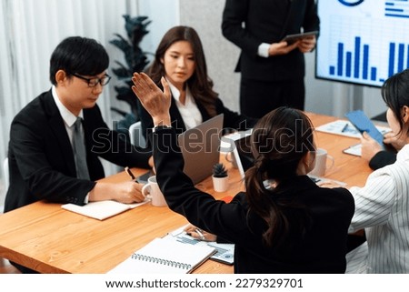 Harmony group businesspeople in meeting room during presentation with dashboard BI financial data displayed on screen, motivated employee raising hand asking question as productive teamwork concept. Royalty-Free Stock Photo #2279329701