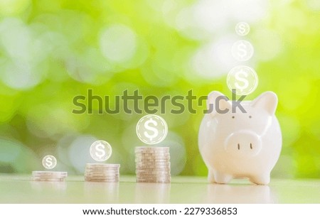 Saving coins money and financial concept bank, Image piggy bank saving money with white color piggy put on wooden table nature green background.
