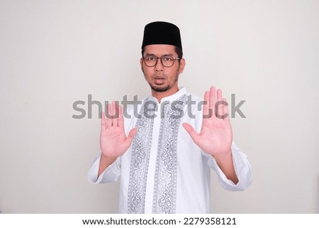 Moslem Asian man give stop hand sign with serious expression