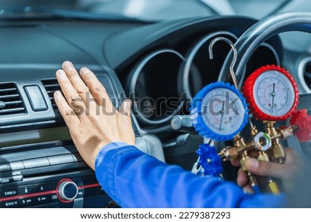 Repairman holding monitor tool to check and fixed car air conditioner system, Technician check car air conditioning system refrigerant recharge, Air Conditioning Repair Royalty-Free Stock Photo #2279387293