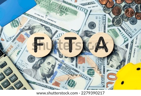 FTA text in wooden circle on Banknotes background, credit card, piggybank, calculator. Free trade agreement, planning goals, opportunity, challenge, Budget, business strategy and financial concept. Royalty-Free Stock Photo #2279390217