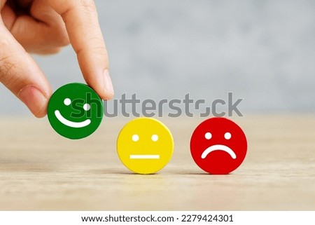 hand holding emotion face block. Customer choose Emoticon for user reviews. Service rating, ranking, customer review, satisfaction, mood, evaluation and feedback concept Royalty-Free Stock Photo #2279424301
