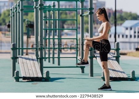 Healthy young caucasian brunette girl in sportswear training at sport court outdoors. Beautiful American student at exercise on Sunday morning. Fitness, workout, active people.