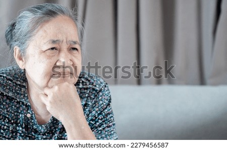 Senior Asian grey-haired woman wearing casual clothes skeptic and nervous, disapproving expression on face.  Mistrustful, confused, shy, trustless, scared, evil person. Royalty-Free Stock Photo #2279456587
