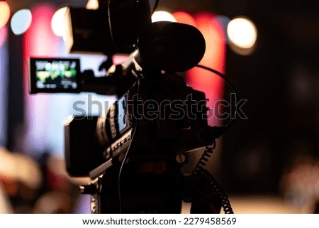 A professional film camera in action. Filming the event. Royalty-Free Stock Photo #2279458569