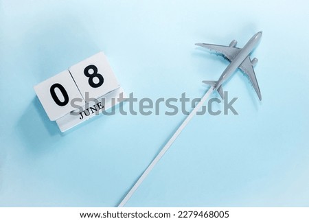 June calendar with number  8. Top view of a calendar with a flying passenger plane. Scheduler. Travel concept. Copy space.