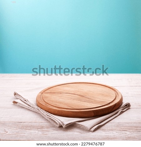 Get an exquisite experience with this high-quality wooden pizza board and napkin. Bread And Fruit Cutting Board and Blue pastel background top view mock up. Royalty-Free Stock Photo #2279476787