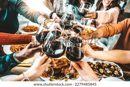 Happy friends toasting red wine glasses at dinner party - Group of people having lunch break at bar restaurant - Life style concept with guys and girls hanging out together - Food and beverage  Royalty-Free Stock Photo #2279485845