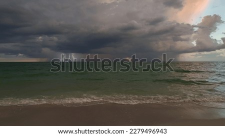 Dark stormy clouds forming on gloomy sky during heavy rainfall season over sea surface in evening