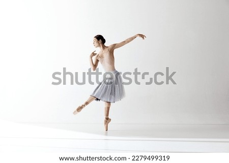 Graceful ballerina, ballet. Beautiful woman dancer dancing over white background. Art, motion, action, flexibility, inspiration concept. Beauty of contemporary dance