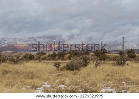 Epic landscape with gorgeous red rock mountain range covered in snow and fog in rural New Mexico Royalty-Free Stock Photo #2279523995