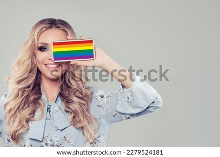 Young woman with smartphone with LGBT flag on it.
