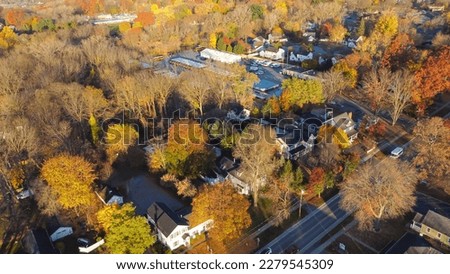 Aerial view Penfield small town USA with local business, church building, residential houses by colorful fall foliage, Upstate New York, America. Bright autumn leaves along Five Mile Line Street