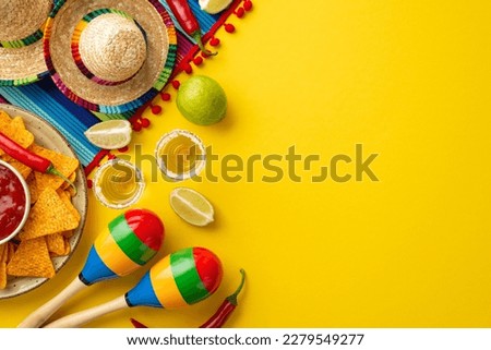 Cinco-de-mayo celebration concept. Top view photo of nacho chips salsa sauce chilli tequila with salt lime sombrero hats colorful serape and maracas on isolated bright yellow background with copyspace Royalty-Free Stock Photo #2279549277