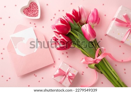 Mother's Day concept. Top view photo of bouquet of tulips present boxes with bows envelope postal with heart and saucer with sprinkles on isolated pastel pink background