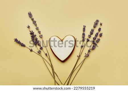 Aesthetics cookie in shape of heart with lavender. Womens Day, Mothers Day. Spring card with baked glazed cookies on yellow background. Feminine background.