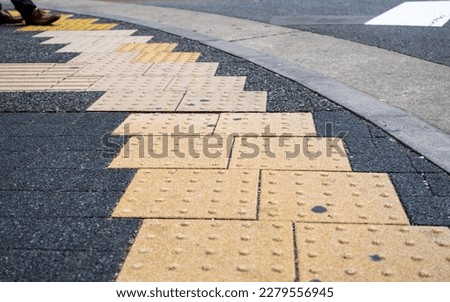 Japanese Yellow Tenji Blocks or tactile paving at a road crossing in Tokyo, Japan