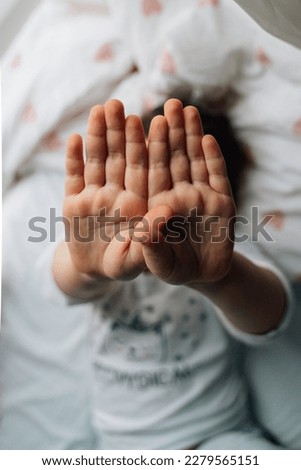Vertical photo of child hand with blurred background. stop gesture. lifestyle at home