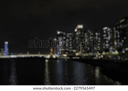 Abstract blur bokeh light cityscape with bridge, building and lake