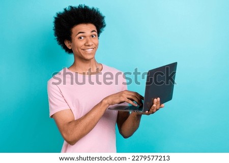 Photo of positive funny smiling young programmer it developer studying code python typing computer isolated on aquamarine color background