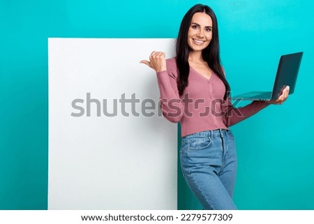 Photo of cheerful glad girl wear stylish clothes hold netbook acer brand point finger whiteboard social media isolated on aquamarine color background