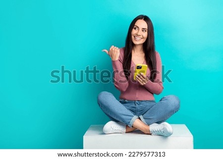 Full body photo of young beautiful girl hold smartphone wear casual outfit direct finger look mockup website isolated on cyan color background
