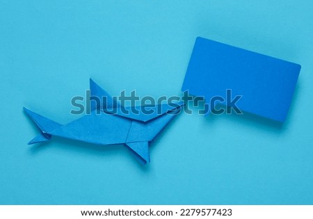 Origami shark with empty speech bubble on blue background