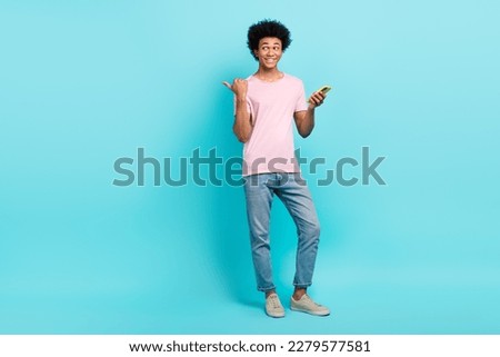 Full body cadre of youth business man influencer direct finger empty space eshop offer hold smartphone promo isolated on aquamarine color background