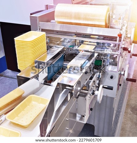 Industrial machine for packing plastic boxes in food production