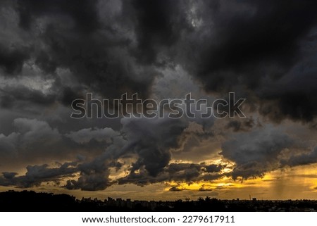 Dark clouds and rainy over the city in Brazil at a sunset