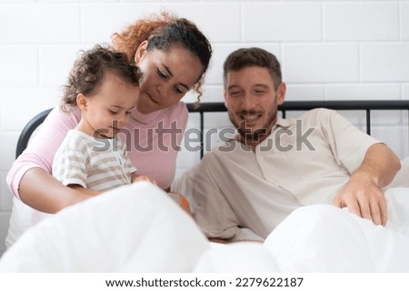 Little girl's father read stories to children before going to bed to unwind and sleep soundly until the morning.