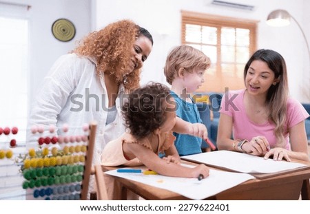 A little child's imagination is represented through colored pencil drawings, with the mother attentively supervising in the living room of the house.