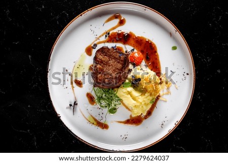 Grilled beef steak filet mignon with potato and sauce in plate Royalty-Free Stock Photo #2279624037